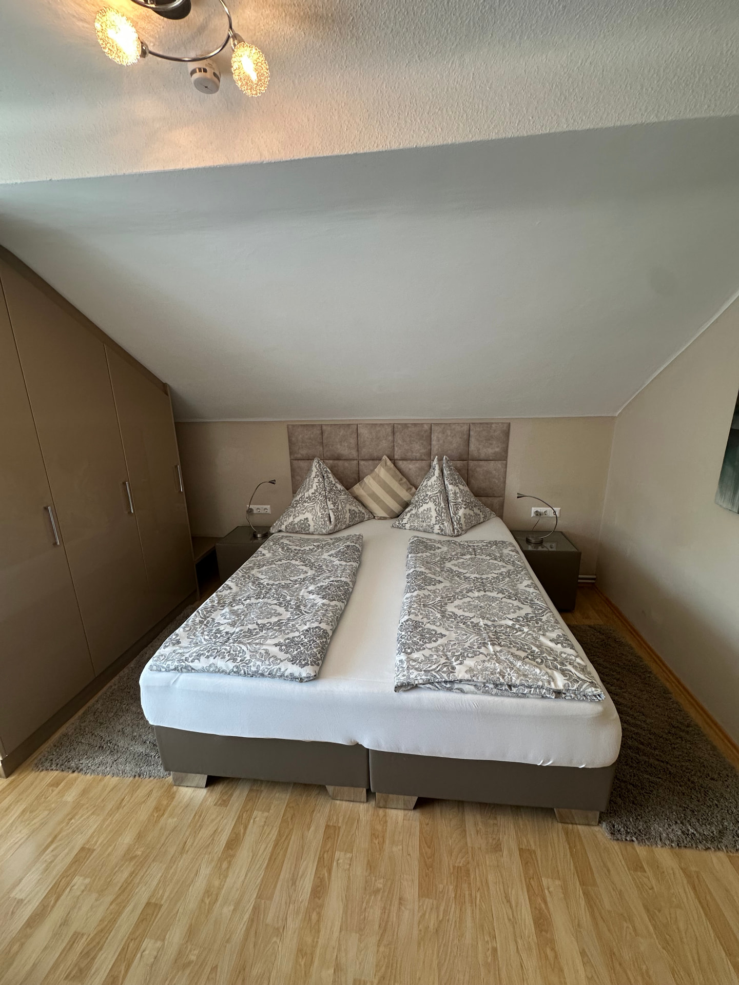 Zimmer mit Doppelbett und Kleiderschrank